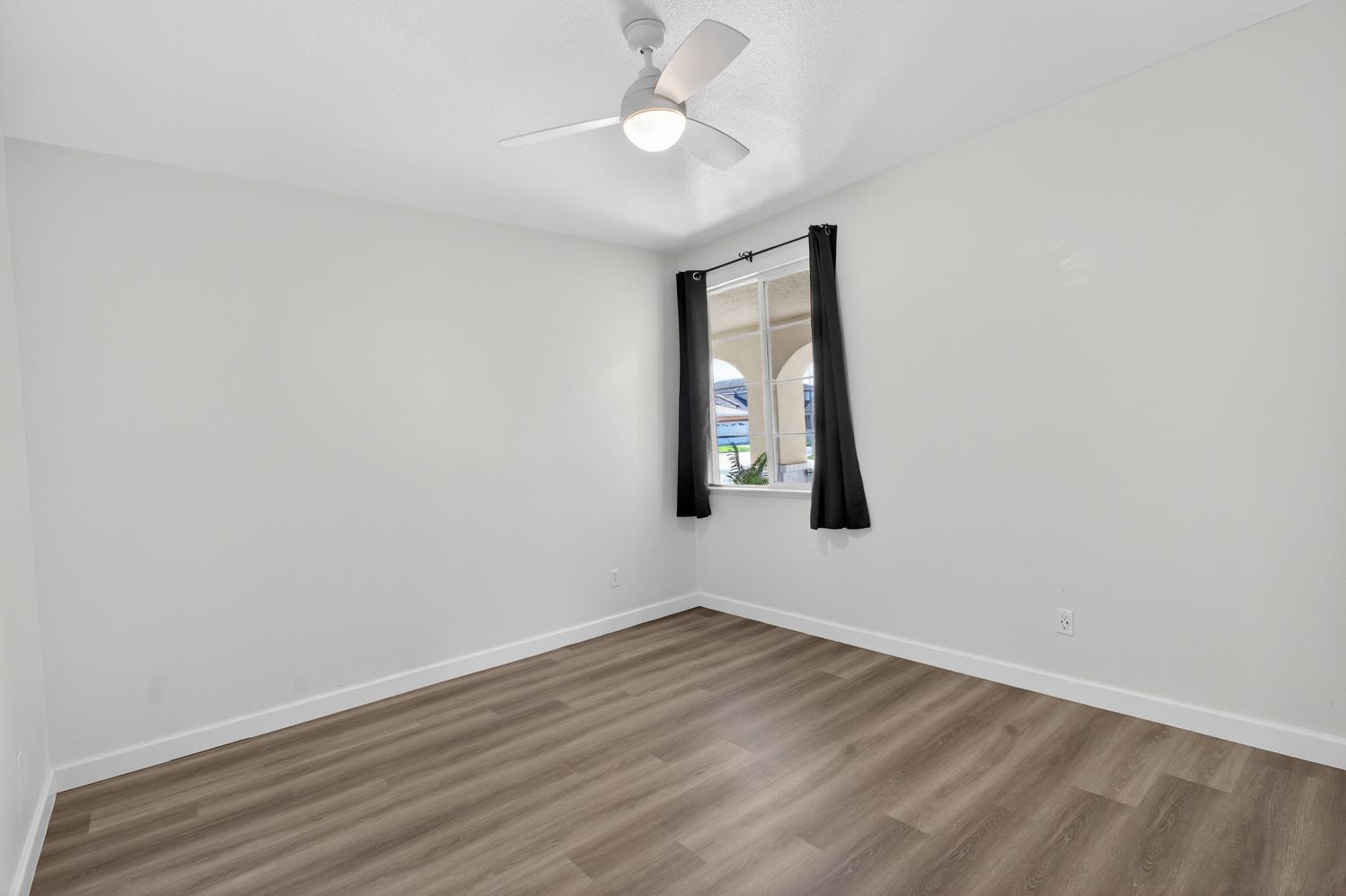 6217 Jefjen Way Elk Grove, CA 95757 - Photo 30 of 58 an empty room with wooden floor ceiling fan and windows