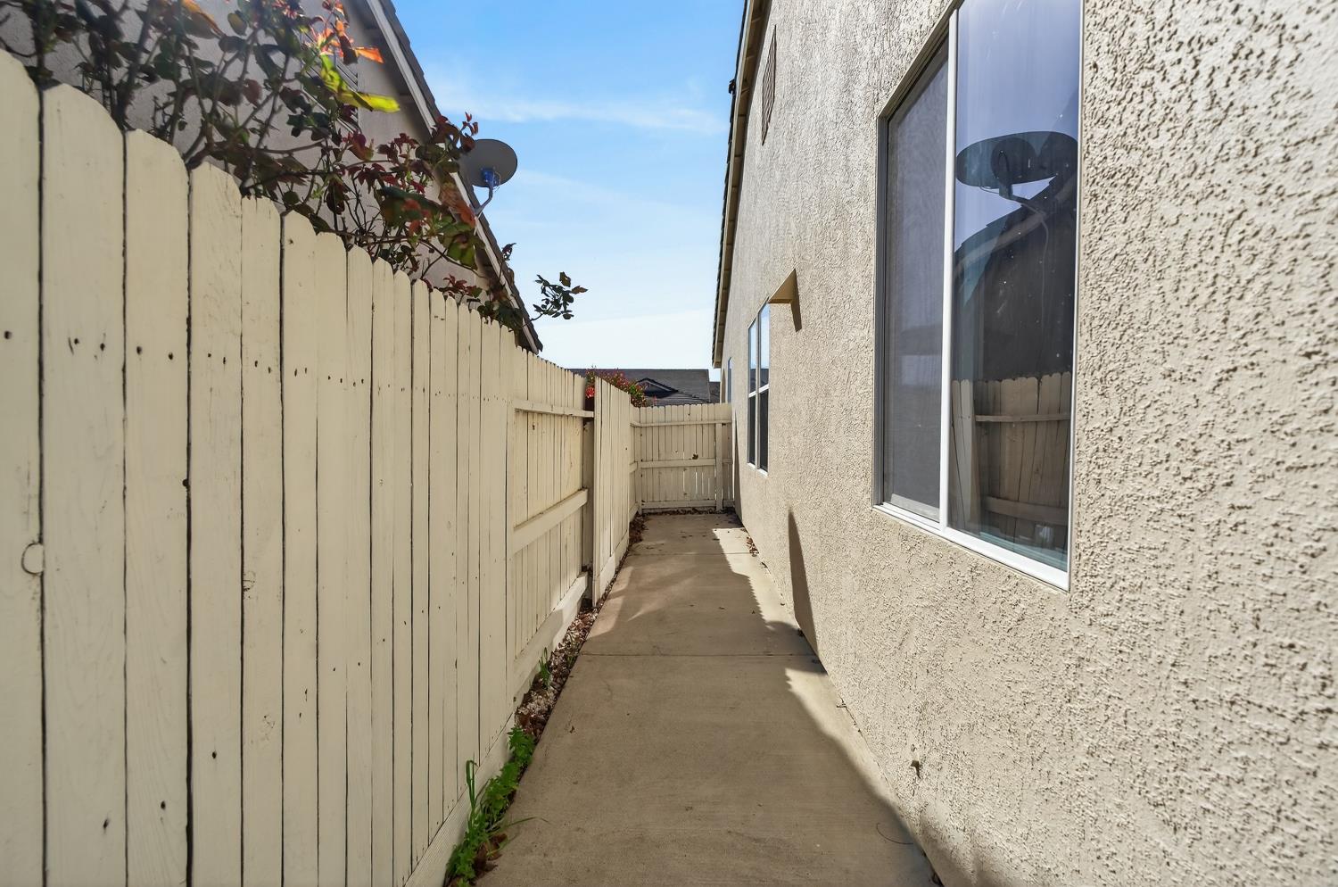 6217 Jefjen Way Elk Grove, CA 95757 - Photo 46 of 58 a view of a pathway of a house with wooden fence and shower