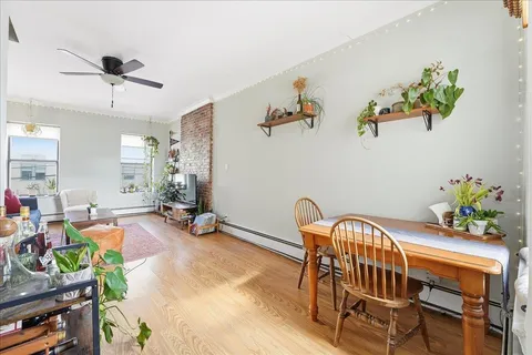 a view of a dining room with furniture a chandelier and wooden floor