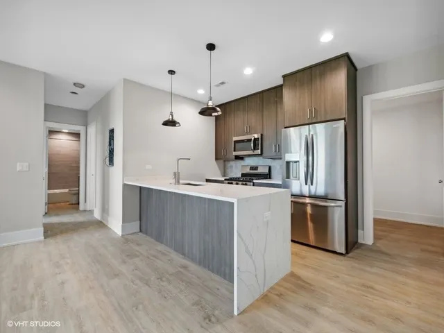 a kitchen with stainless steel appliances a refrigerator and a stove top oven