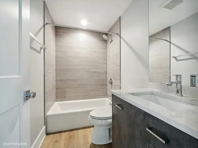 a bathroom with a granite countertop sink a toilet and shower