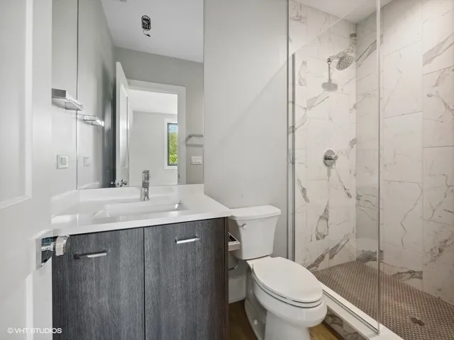 a bathroom with a granite countertop toilet sink and shower