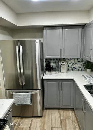 a kitchen with stainless steel appliances granite countertop a sink and a refrigerator