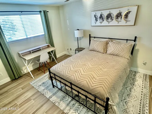 a bedroom with a bed and wooden floor