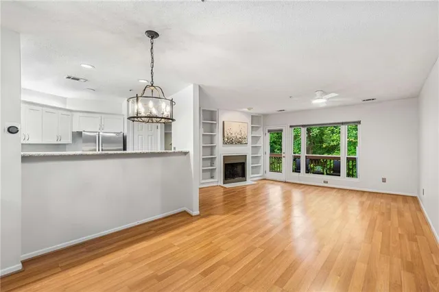 a view of a kitchen with wooden floor and a window