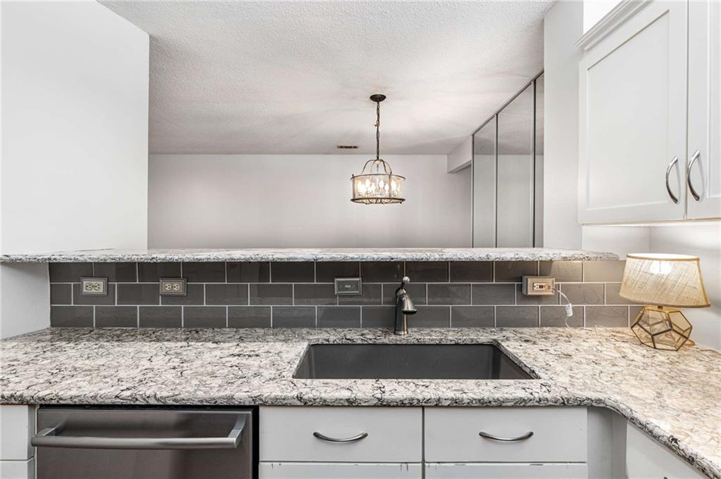 490 Sherman Way Decatur, GA 30033 - Photo 11 of 44 a kitchen with kitchen island granite countertop a sink and a stove