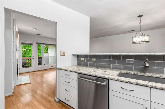 a kitchen with granite countertop a sink cabinets and wooden floor