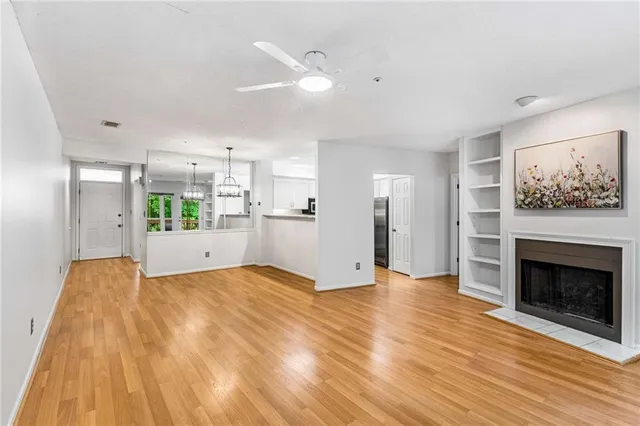 a view of a livingroom with wooden floor and a fireplace