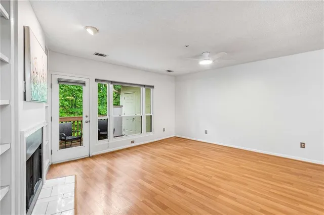 a view of an empty room with a fireplace and a window