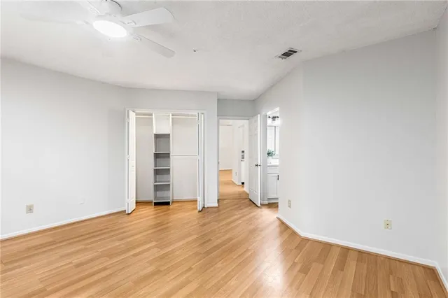a view of empty room with wooden floor and window