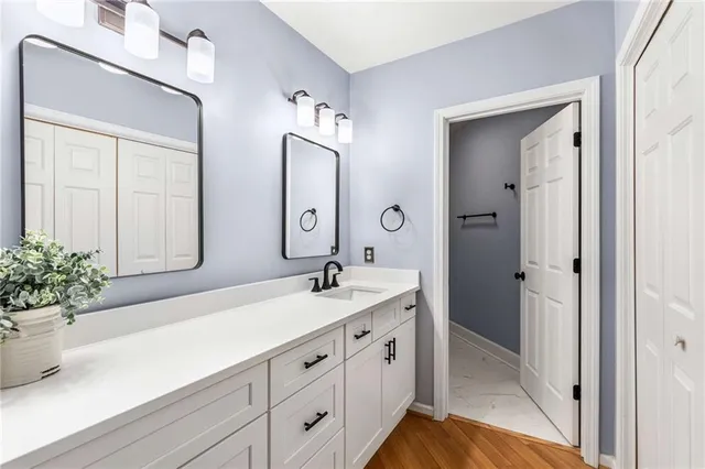 a spacious bathroom with a granite countertop sink and a mirror