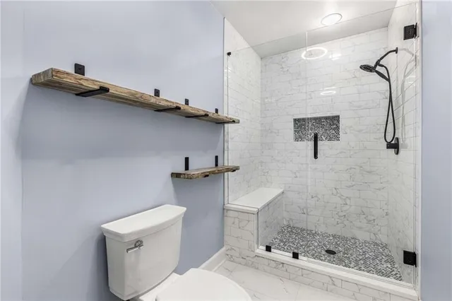 a bathroom with a toilet and a shower