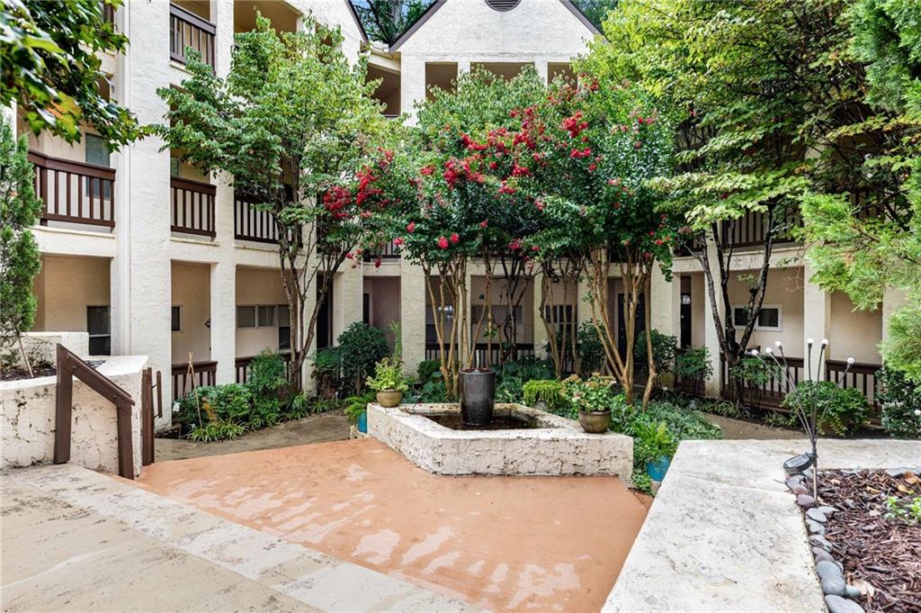 490 Sherman Way Decatur, GA 30033 - Photo 5 of 44 a view of a white house with a yard and table and chairs under an umbrella