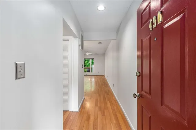 a view of a hallway with wooden floor and staircase