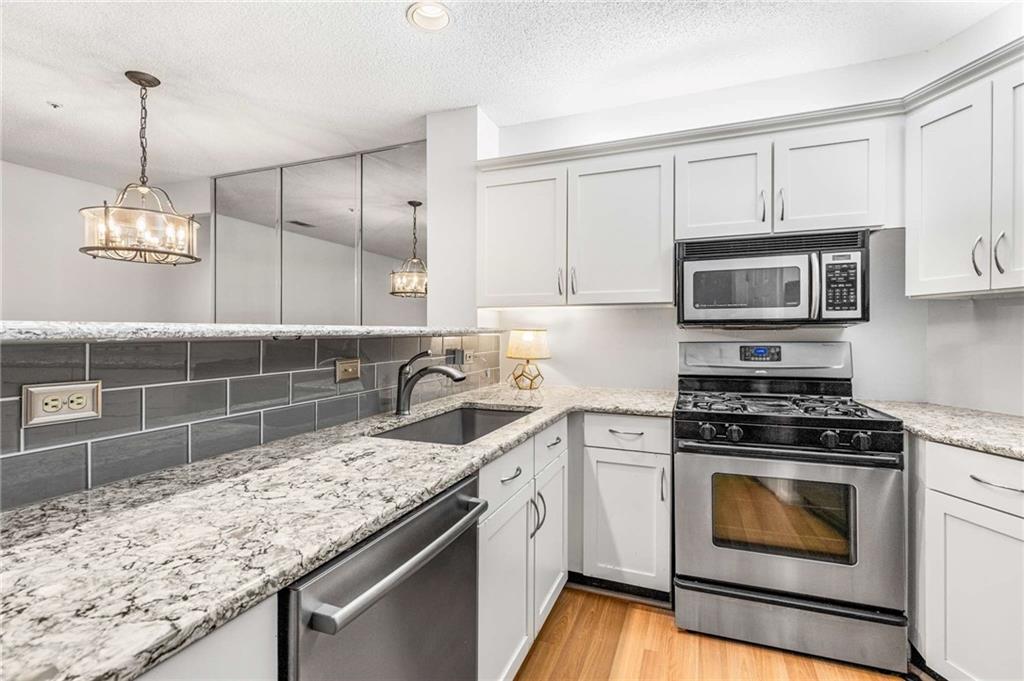 490 Sherman Way Decatur, GA 30033 - Photo 10 of 44 a kitchen with granite countertop a sink a stove and microwave