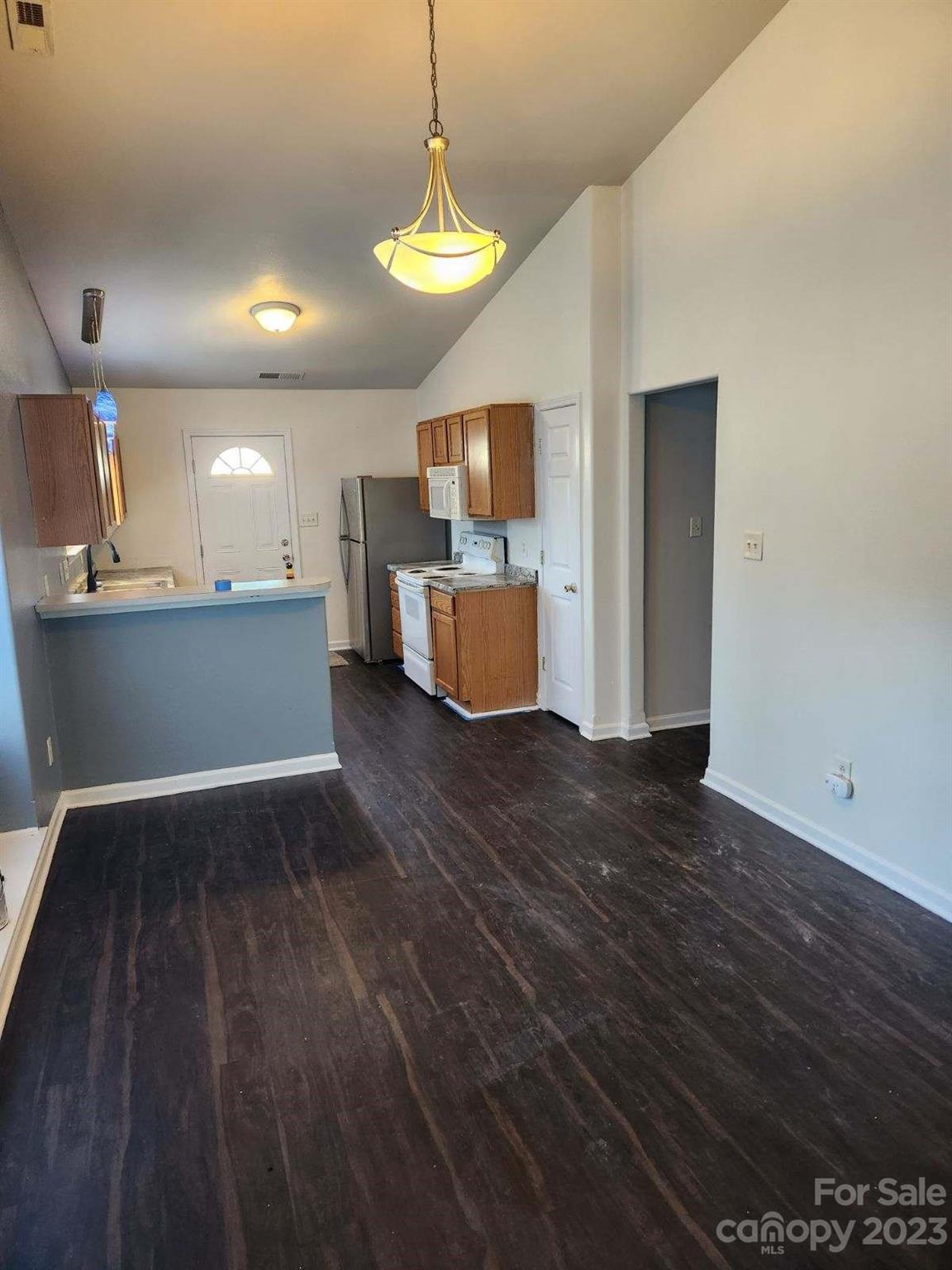 2865 Oasis Lane Charlotte, NC 28214 - Photo 3 of 15 a kitchen with a wooden floor and a refrigerator