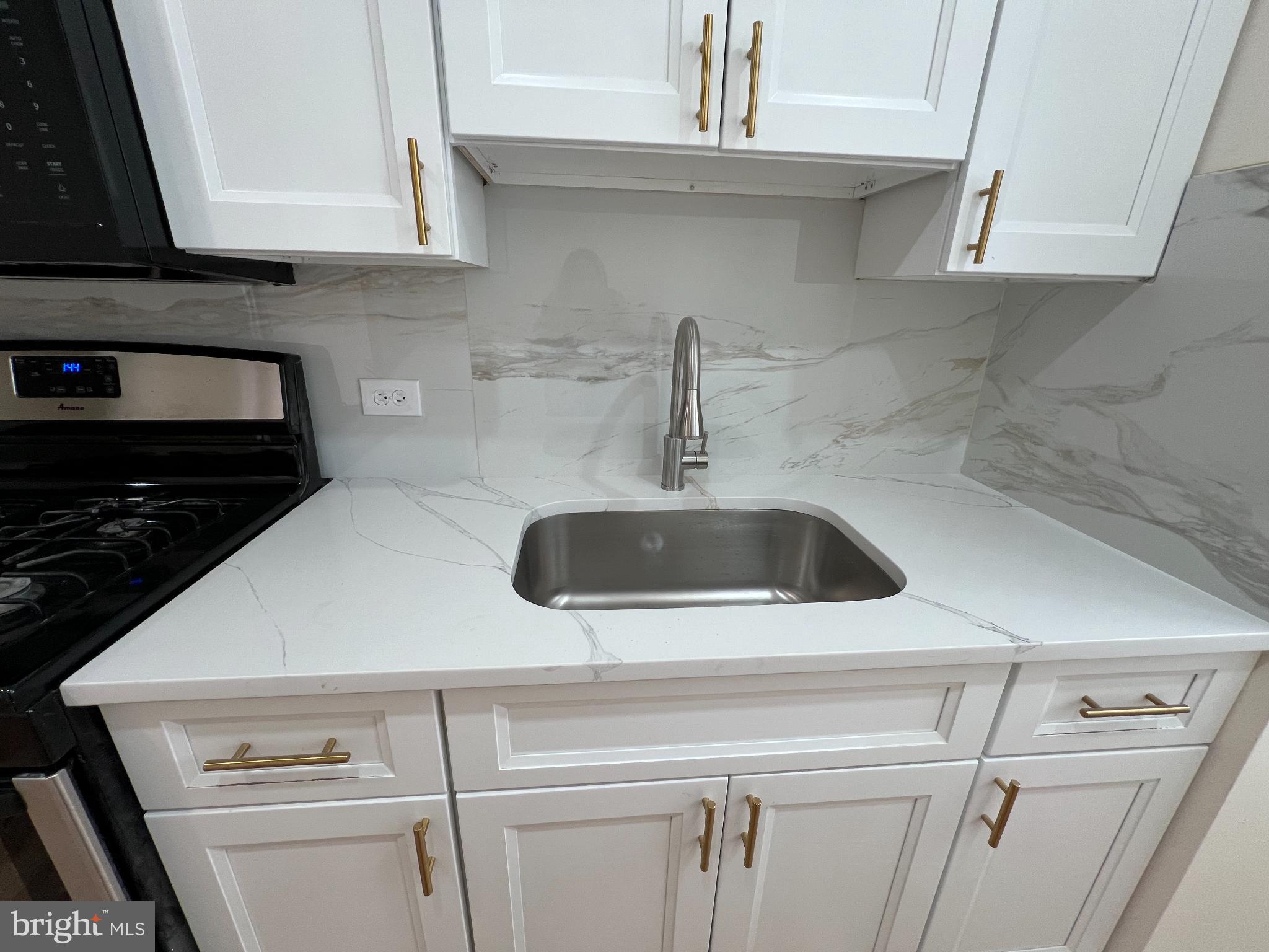 4345 Loring Street Philadelphia, PA 19136 - Photo 4 of 16 a kitchen with a sink a stove and cabinets