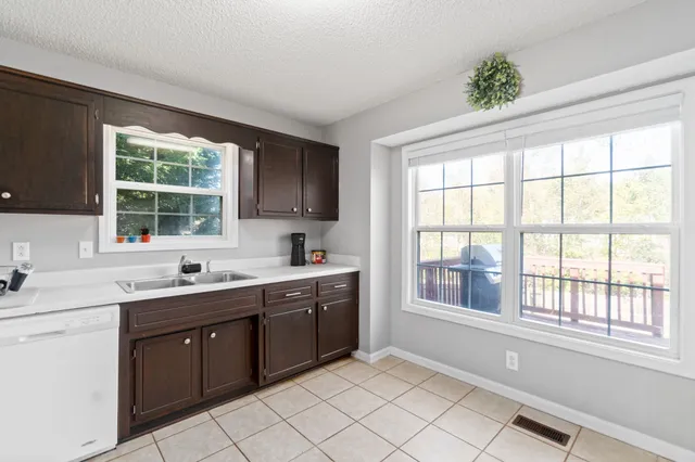 a kitchen with a sink window and cabinets