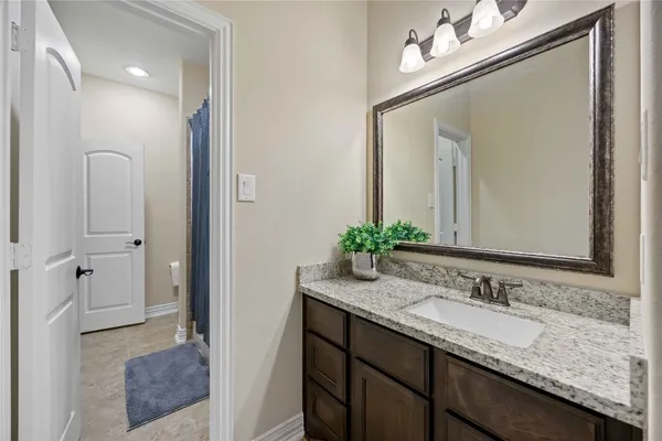 a bathroom with a granite countertop sink and a mirror