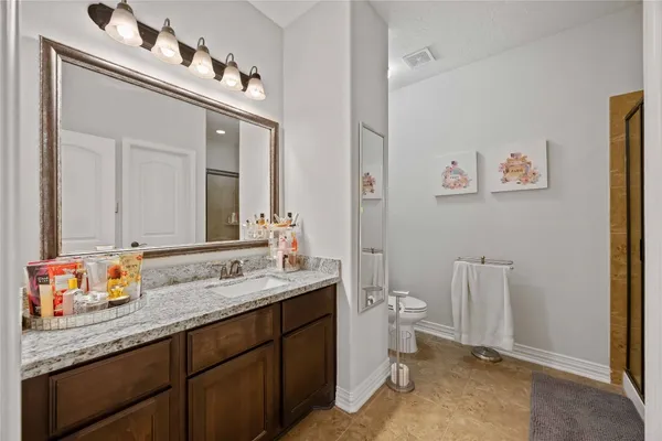 a spacious bathroom with a granite countertop sink and a mirror