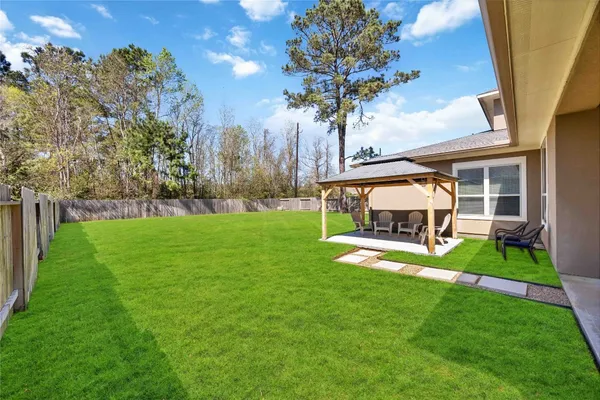 a view of a house with backyard and a tree