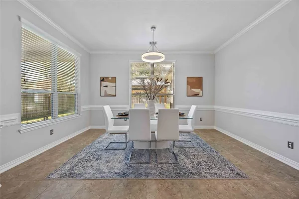 a dining room with wooden floor a rug a couch and a chandelier