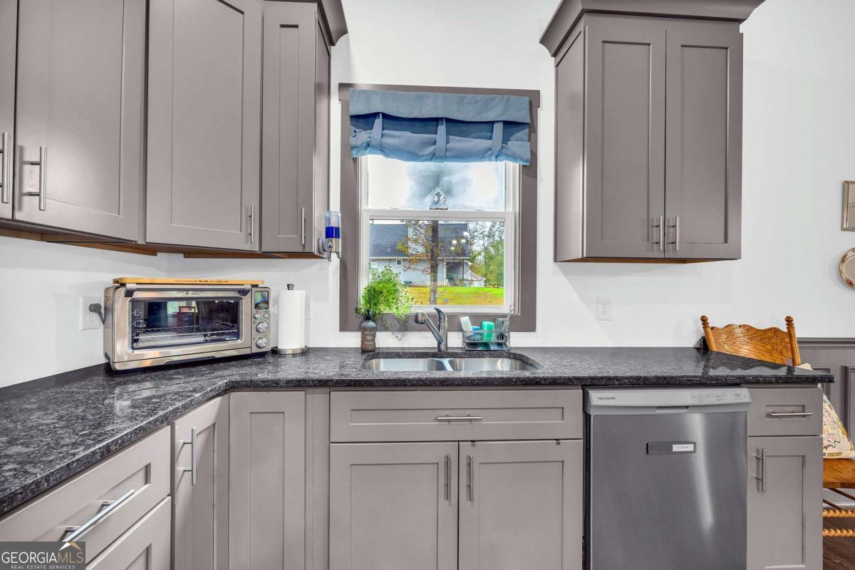 153 North Point Circle Hartwell, GA 30643 - Photo 22 of 60 a kitchen with granite countertop white cabinets and a window