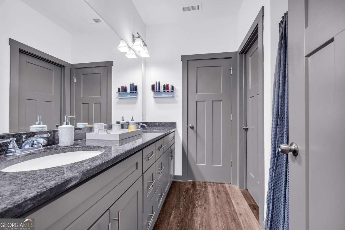 153 North Point Circle Hartwell, GA 30643 - Photo 34 of 60 a en suite bathroom with a granite countertop sink a mirror and a shower