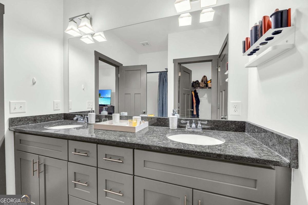 153 North Point Circle Hartwell, GA 30643 - Photo 36 of 60 a bathroom with a granite countertop sink a large mirror and vanity