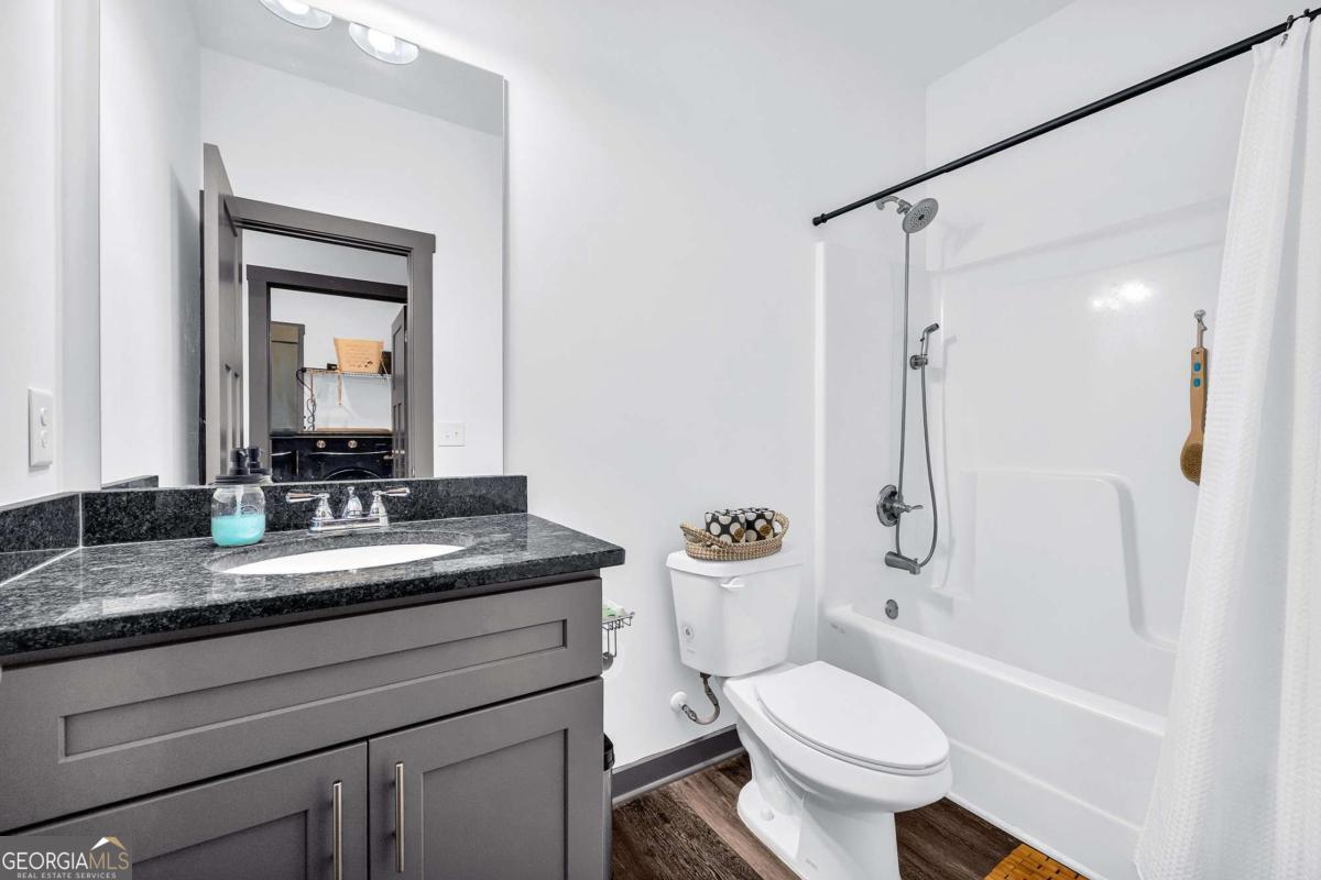 153 North Point Circle Hartwell, GA 30643 - Photo 45 of 60 a bathroom with a granite countertop toilet sink and mirror