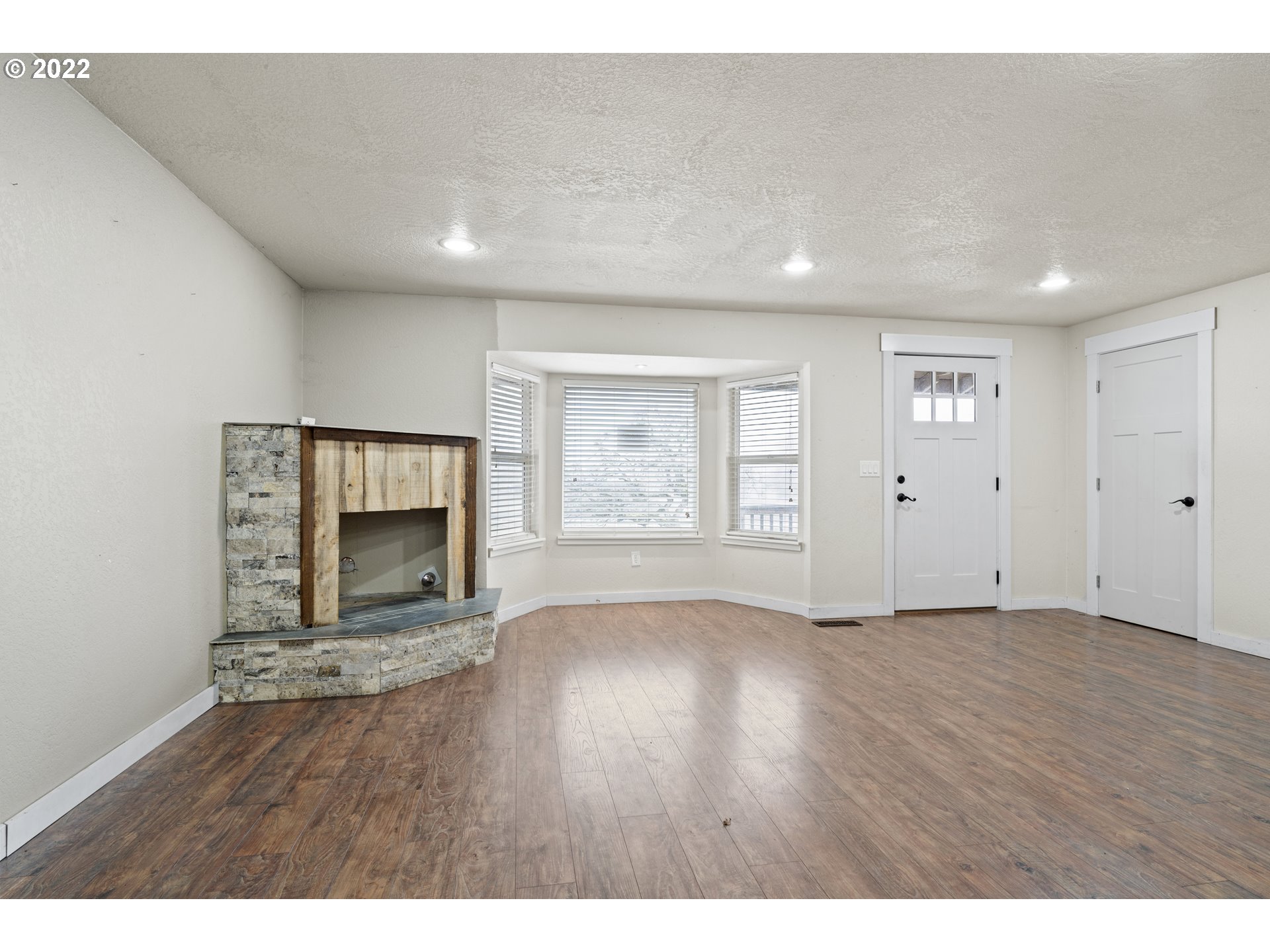 13644 Agate Road Eagle Point, OR 97524 - Photo 4 of 32 a view of an empty room with wooden floor and a window