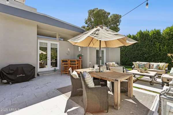 a view of a patio with couple of chairs and potted plants
