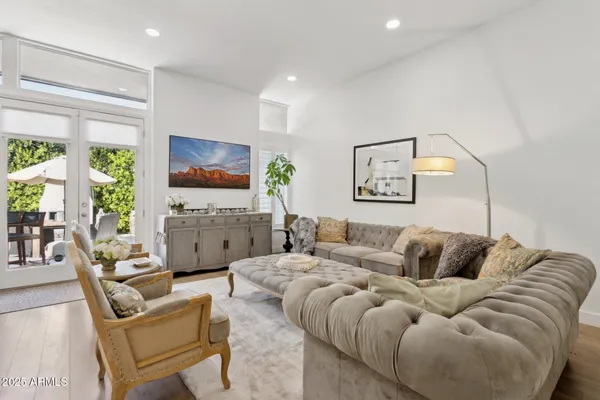 a living room with stainless steel appliances granite countertop furniture a fireplace a rug and a window