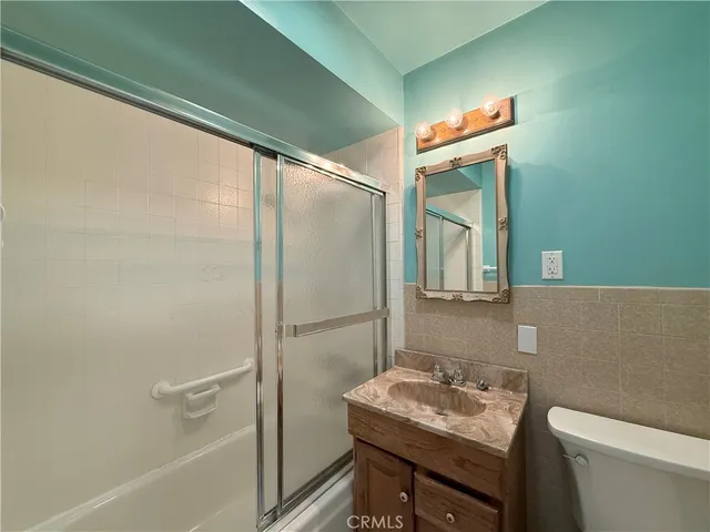 a bathroom with a sink toilet vanity and shower