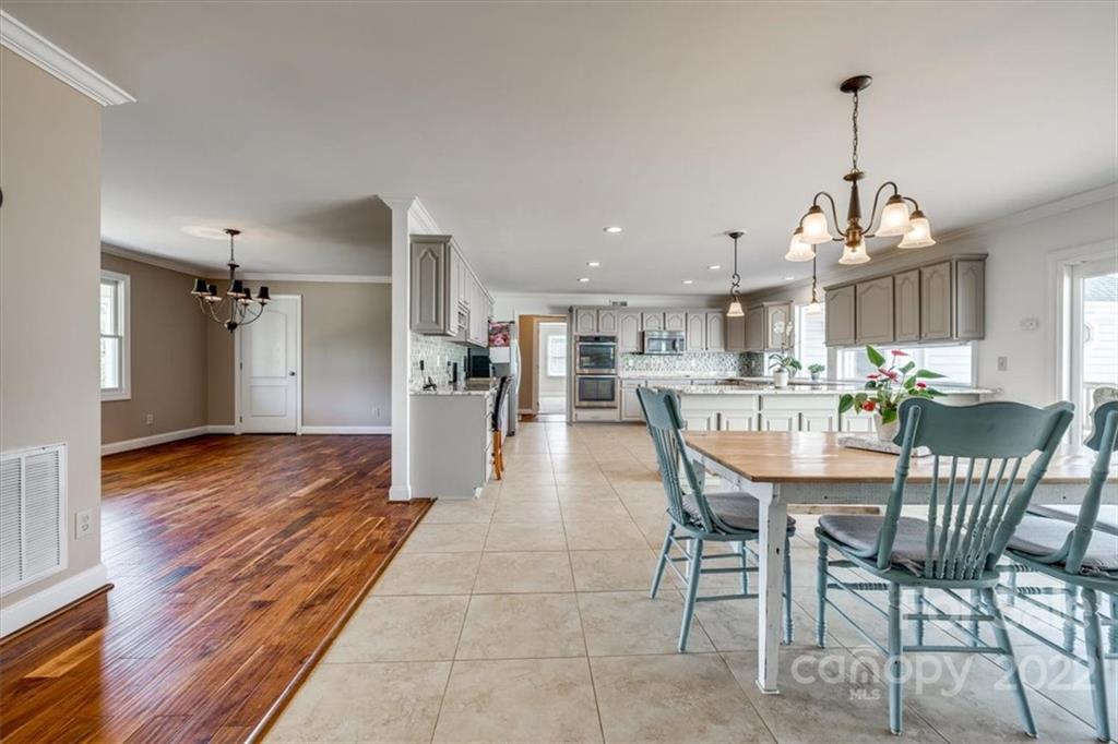 5249 Willow Pond Road Lake Wylie, SC 29710 - Photo 19 of 45 a dining room with stainless steel appliances kitchen island granite countertop a dining table chairs and chandelier