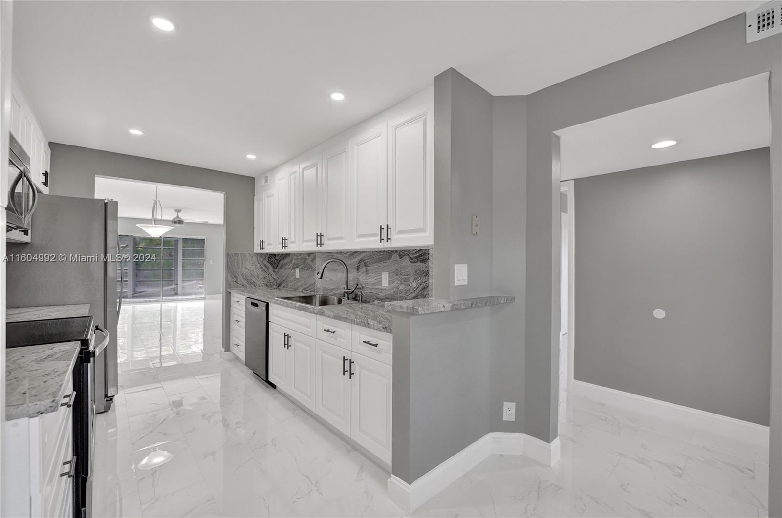 1802 Eleuthera Point, Unit E3 Coconut Creek, FL 33066 - Photo 14 of 78 a kitchen with stainless steel appliances granite countertop a refrigerator and a stove top oven