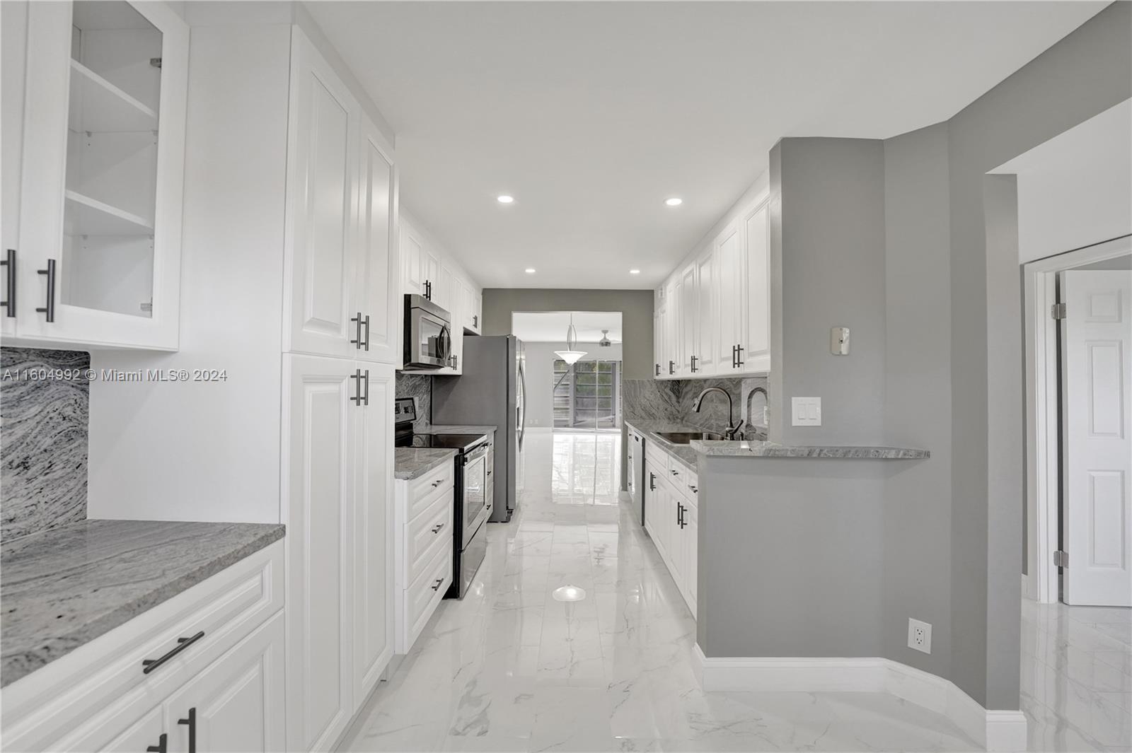 1802 Eleuthera Point, Unit E3 Coconut Creek, FL 33066 - Photo 15 of 78 a kitchen with stainless steel appliances granite countertop a refrigerator and a stove top oven