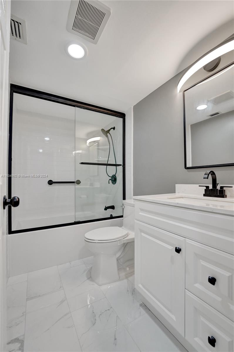 1802 Eleuthera Point, Unit E3 Coconut Creek, FL 33066 - Photo 36 of 78 a bathroom with a sink a mirror and shower