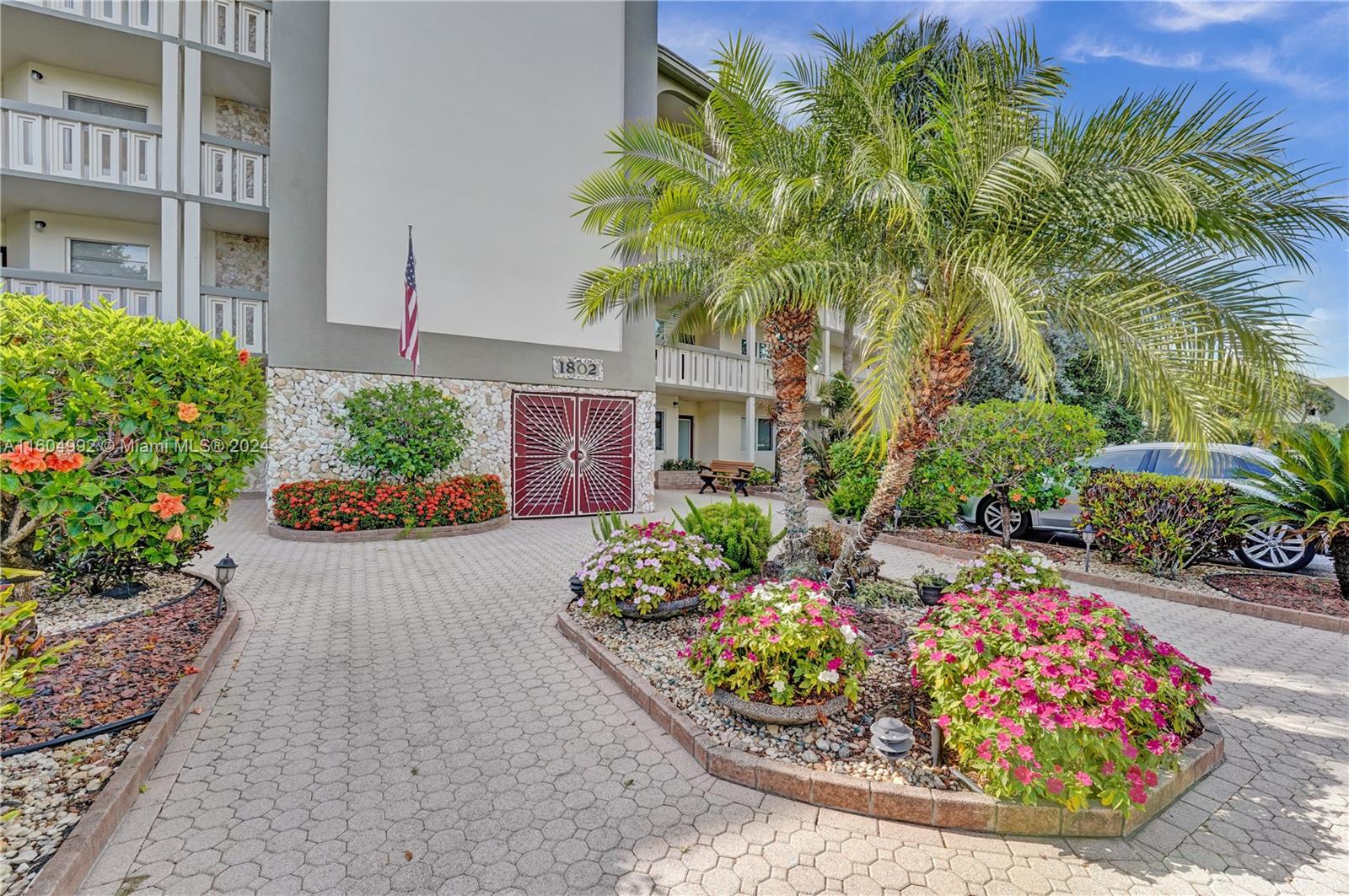 1802 Eleuthera Point, Unit E3 Coconut Creek, FL 33066 - Photo 46 of 78 a front view of a house with a yard and outdoor seating