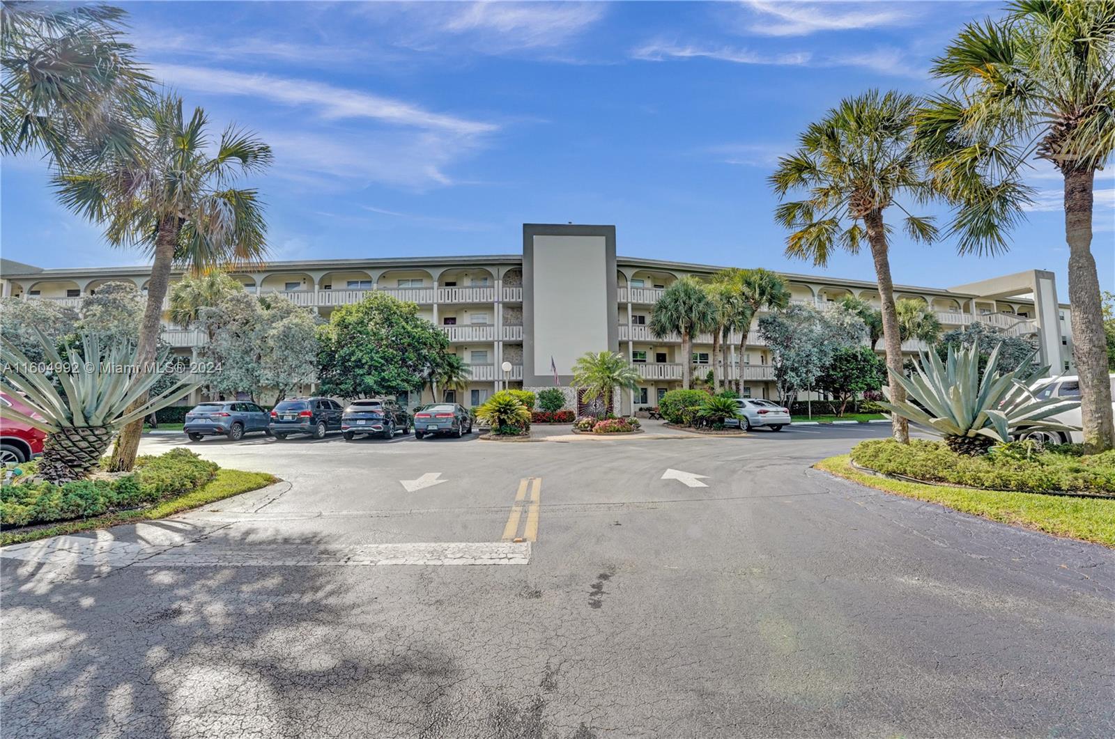 1802 Eleuthera Point, Unit E3 Coconut Creek, FL 33066 - Photo 47 of 78 a front view of a house with a yard and a garage