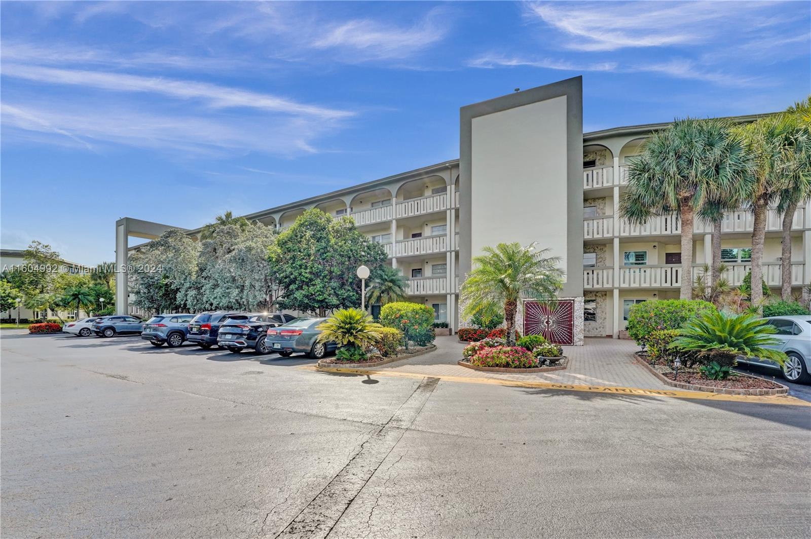 1802 Eleuthera Point, Unit E3 Coconut Creek, FL 33066 - Photo 48 of 78 a view of a street with a building and bench in front of it