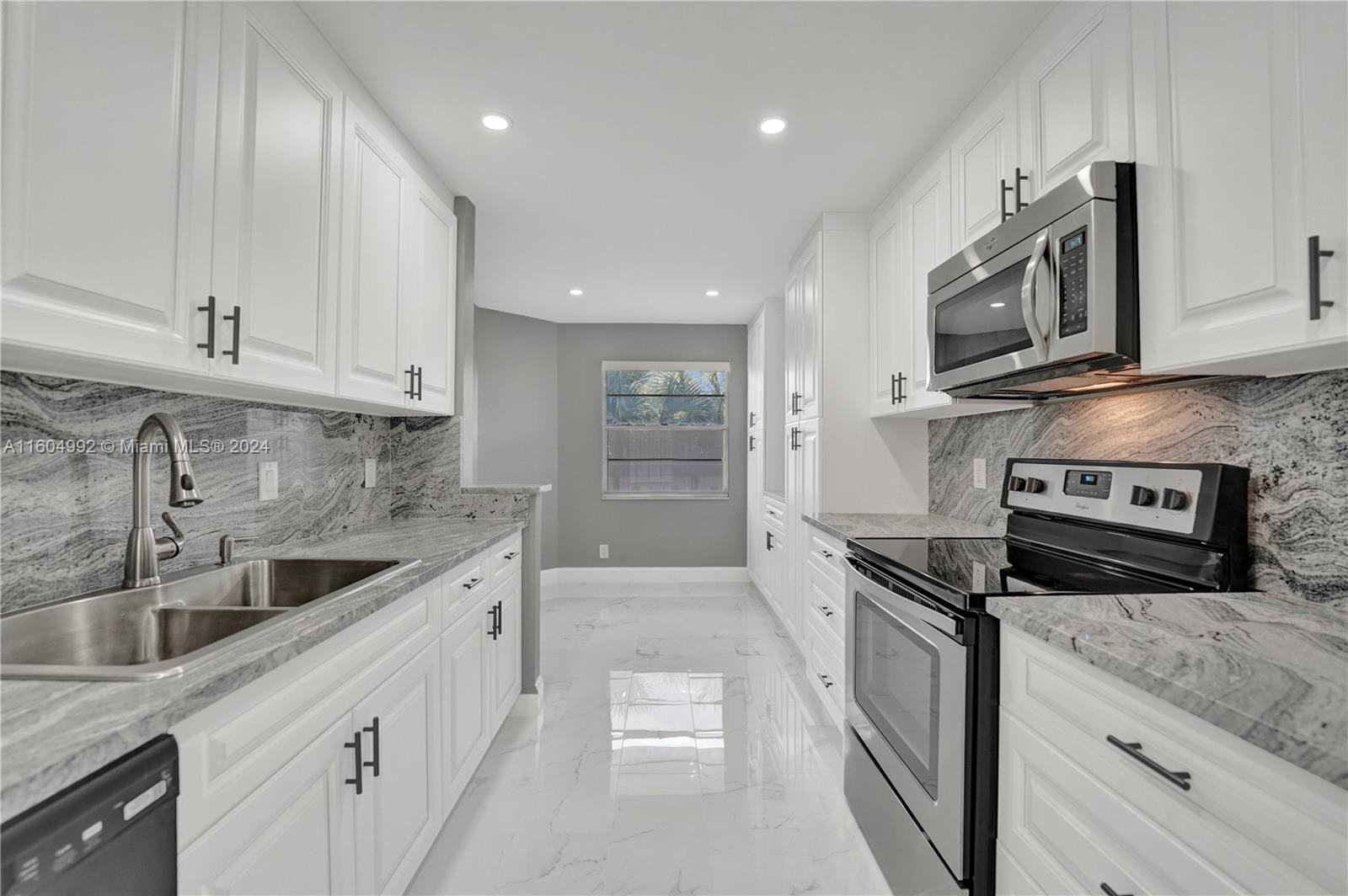 1802 Eleuthera Point, Unit E3 Coconut Creek, FL 33066 - Photo 7 of 78 a kitchen with stainless steel appliances granite countertop a sink and a stove