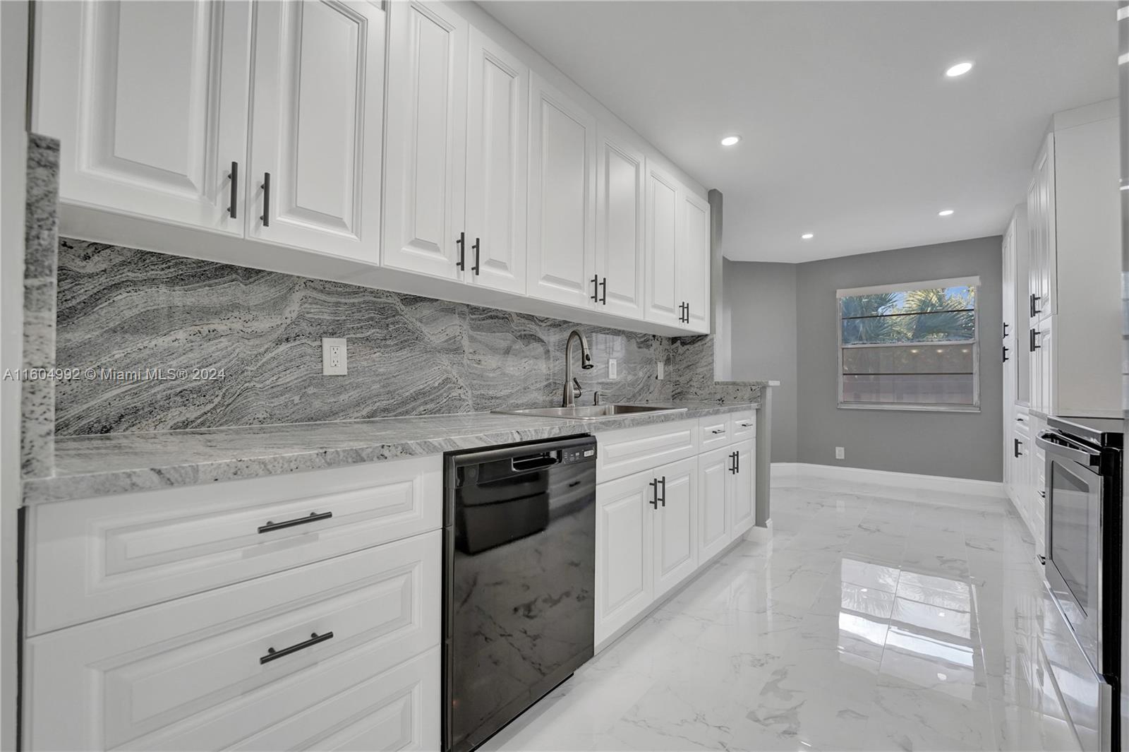 1802 Eleuthera Point, Unit E3 Coconut Creek, FL 33066 - Photo 8 of 78 a kitchen with granite countertop white cabinets and stainless steel appliances