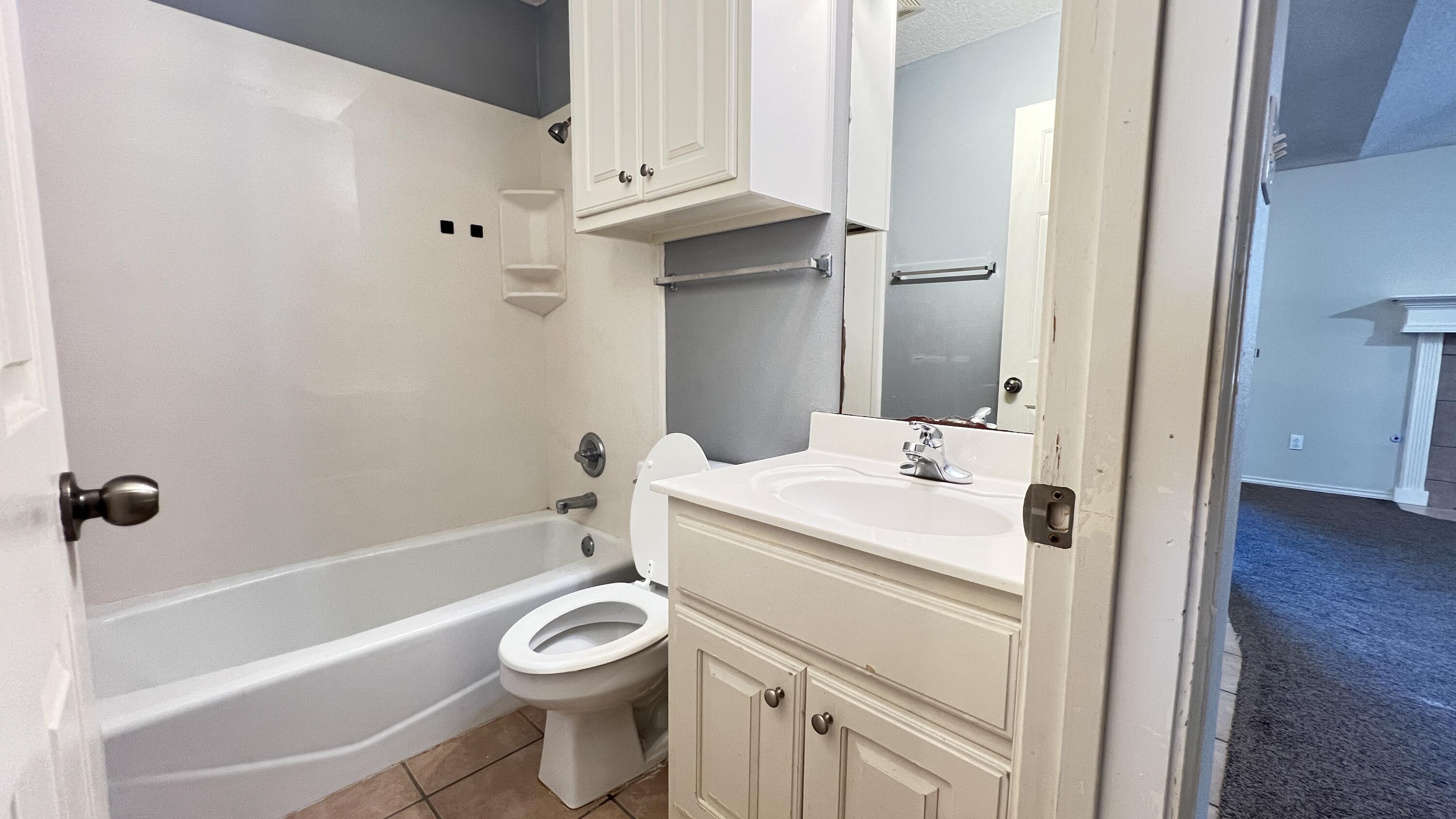 3102 110th Street Lubbock, TX 79423 - Photo 11 of 11 a bathroom with a sink a toilet and a bathtub