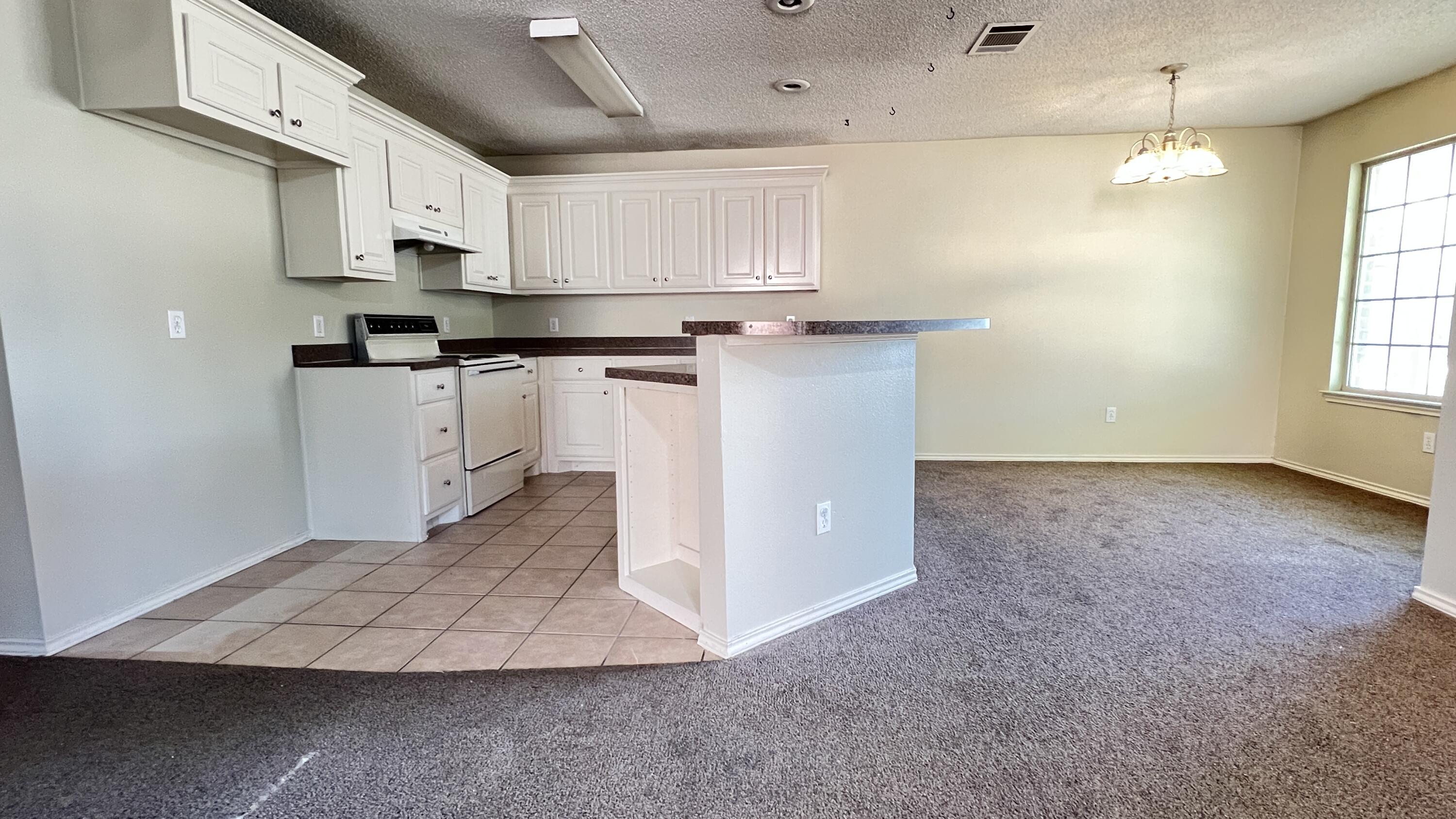3102 110th Street Lubbock, TX 79423 - Photo 5 of 11 a kitchen with stainless steel appliances granite countertop a refrigerator sink and white cabinets
