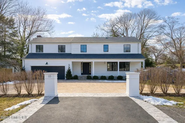 a front view of a house with a yard outdoor seating and garage