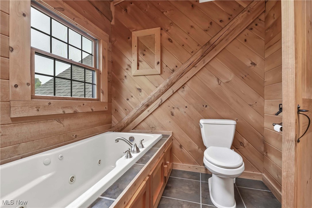 8164 Vandemark Road Lodi, OH 44254 - Photo 27 of 50 View of soaker tub window overlooking back yard, toilet and tile floor in primary bathroom
