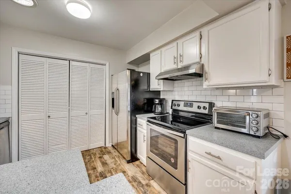a kitchen with stainless steel appliances granite countertop a stove a refrigerator and a cabinets