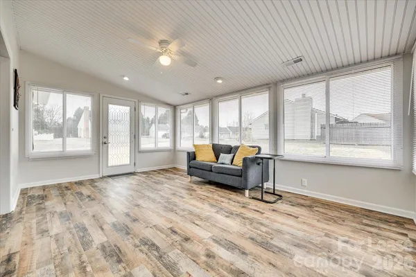 a living room with furniture and large windows