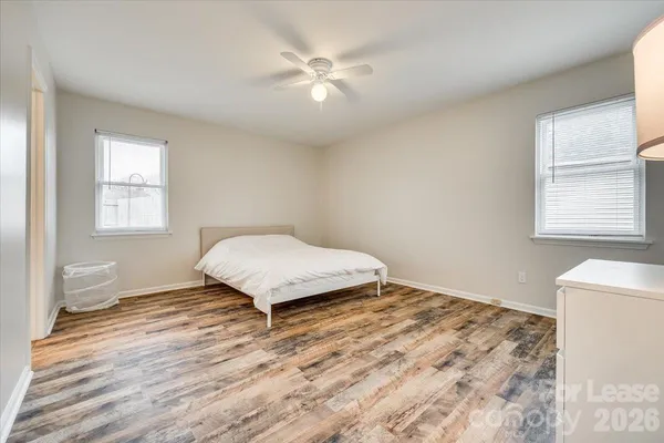 a bedroom with a bed and a window with wooden floor